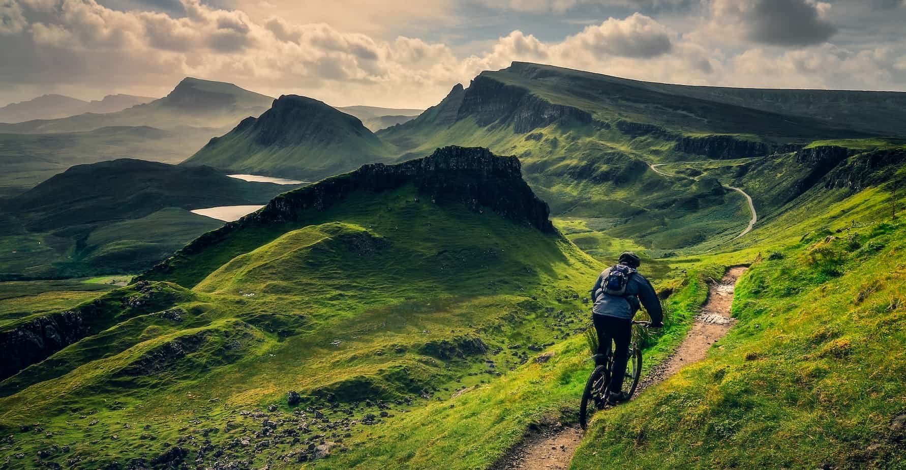 Mountain biker riding through rough mountain landscape of Quiraing, Scotland